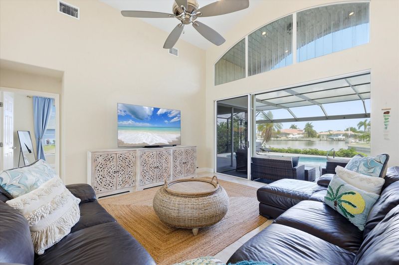 Family room with large sectional sofa, lanai access and 75-inch Smart TV