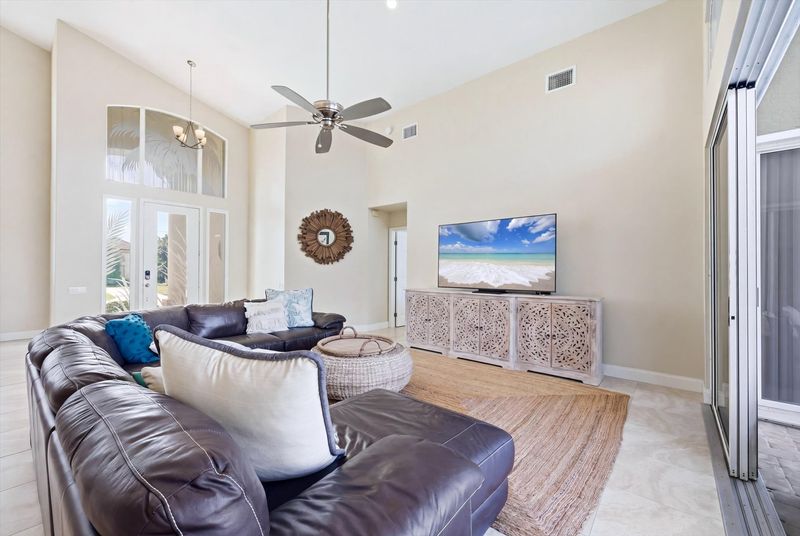 Family room with large sectional sofa, lanai access and 75-inch Smart TV