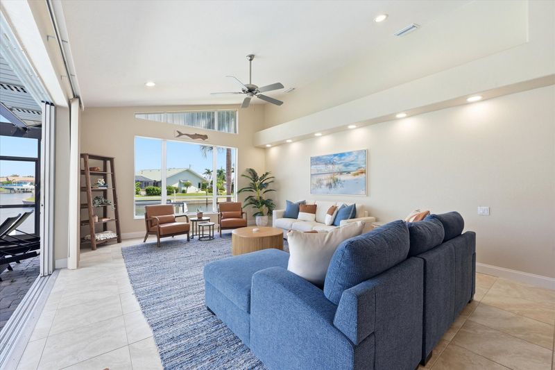 Living room overlooking the pool with lots of comfortable seating and fantastic waterviews