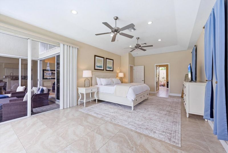 Bedroom 1 - Primary bedroom with king bed, attached bathroom, lanai access, and 43-inch Smart TV