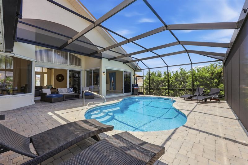 Great outdoor living space overlooking the canal. Features a sparkling pool, sun loungers, and BBQ grill. Pool size: 25' x 13' x 6'D