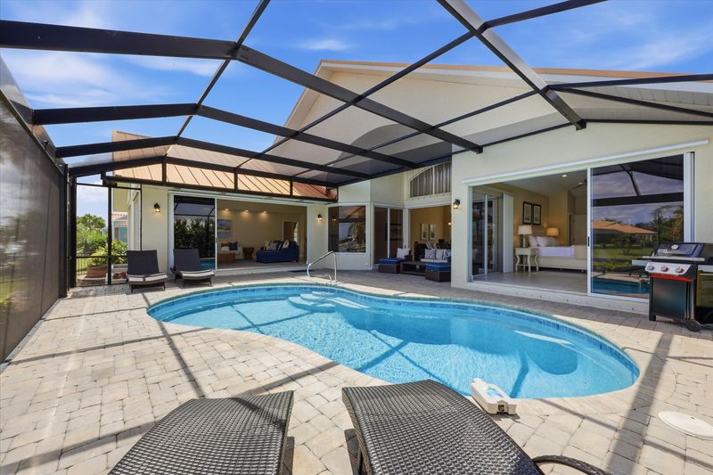 Great outdoor living space overlooking the canal. Features a sparkling pool, sun loungers, and BBQ grill. Pool size: 25' x 13' x 6'D