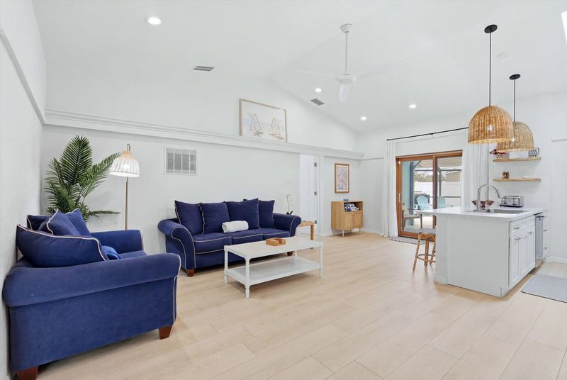 Bright, open living space with comfy seating, 75-inch Smart TV, and lanai access
