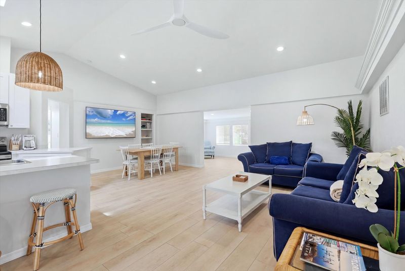 Bright, open living space with comfy seating, 75-inch Smart TV, and lanai access