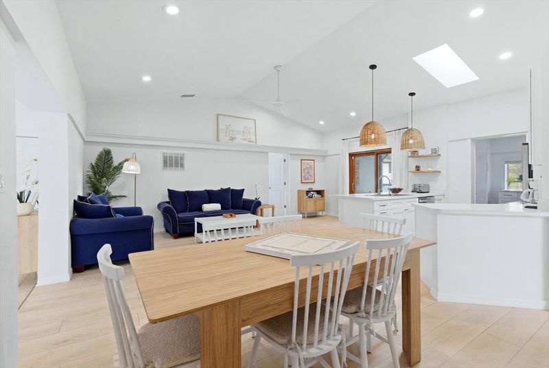 Bright, open living space with comfy seating, 75-inch Smart TV, and lanai access. Dining table seats 6