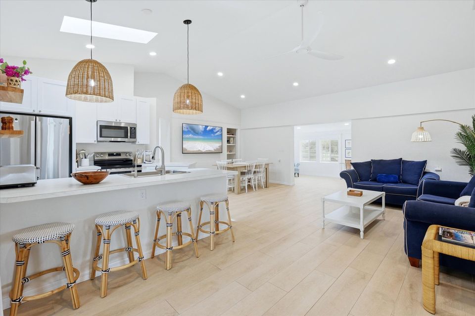Bright, open living space with comfy seating, 75-inch Smart TV, and lanai access