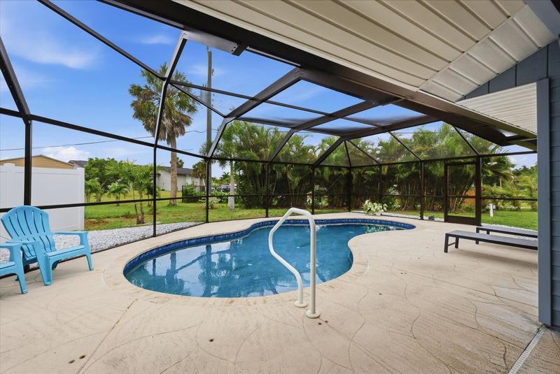 Outdoor living space overlooking sparkling pool. Also features outdoor shower, 2 sun loungers, 55-inch Smart TV, and a propane/pellet BBQ grill. Pool Size 25' x 12' x 5.5'D