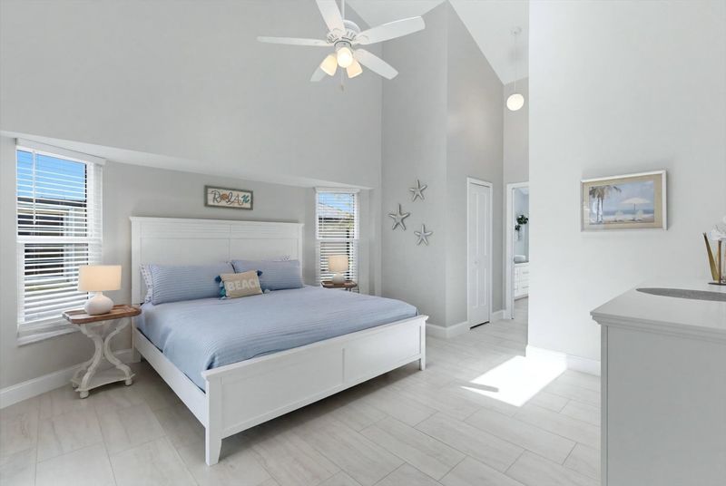 Bedroom 1 - primary bedroom with king bed, attached bathroom, lanai access, and 43" Smart TV