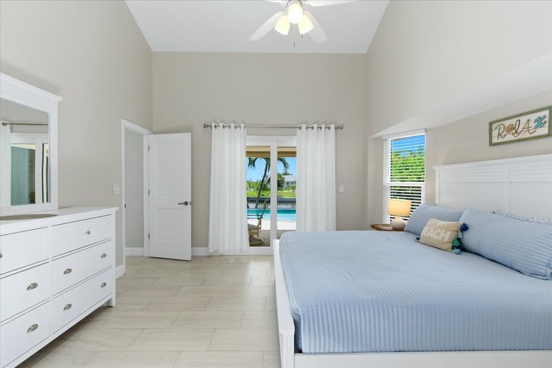 Bedroom 1 - primary bedroom with king bed, attached bathroom, lanai access, and 43" Smart TV