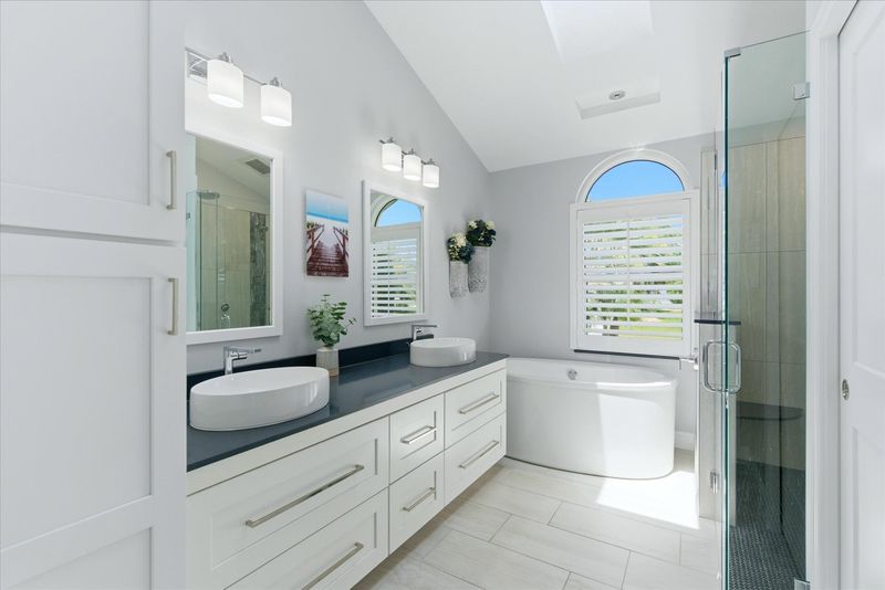 Primary bedroom's attached bathroom with large walk-in shower, soaking tub, and double vanities