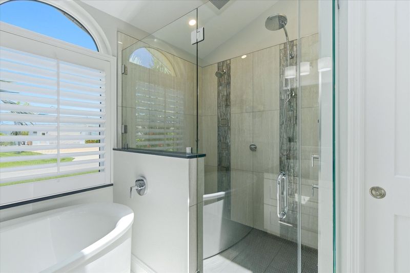 Primary bedroom's attached bathroom with large walk-in shower, soaking tub, and double vanities