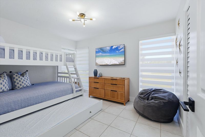 Guest bedroom with twin over double bunkbed with twin trundle, and 55-inch Smart TV