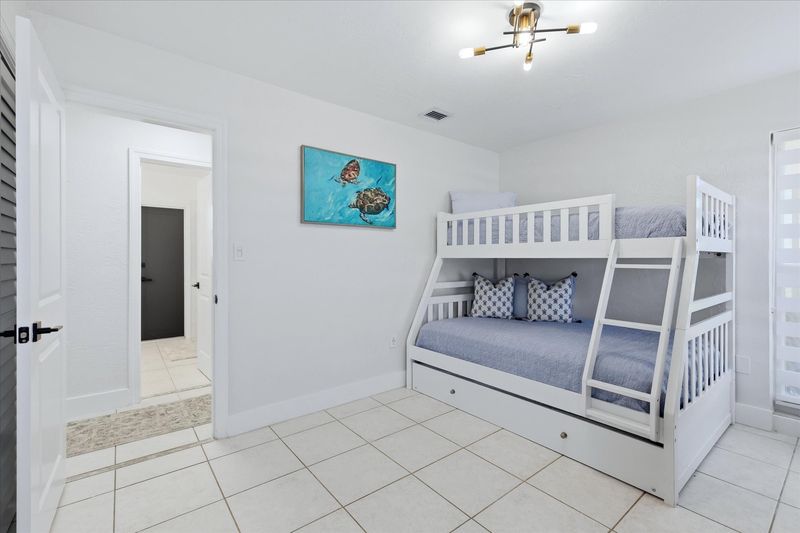 Guest bedroom with twin over double bunkbed with twin trundle, and 55-inch Smart TV