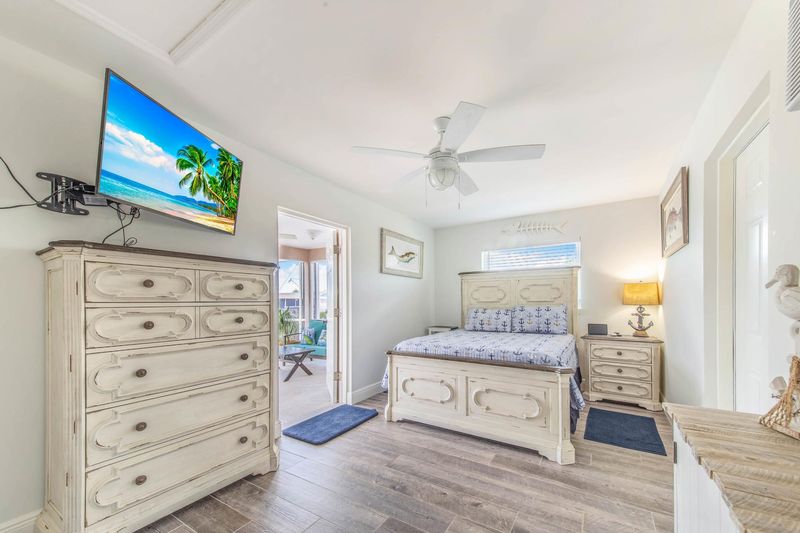 Guest bedroom 3 (off of garage) with full-size bed, attached bathroom, lanai access, 43-inch Smart TV, and private entry