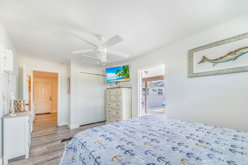Guest bedroom 3 (off of garage) with full-size bed, attached bathroom, lanai access, 43-inch Smart TV, and private entry