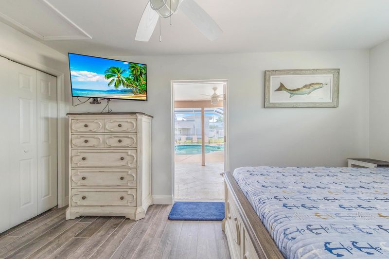 Guest bedroom 3 (off of garage) with full-size bed, attached bathroom, lanai access, 43-inch Smart TV, and private entry