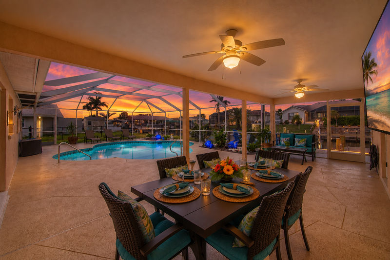 Large outdoor living space with sparkling pool overlooking the canal