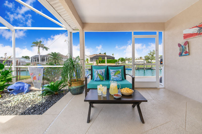 Large outdoor living space with sparkling pool overlooking the canal