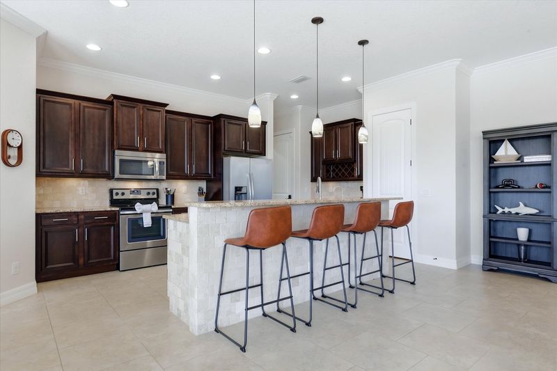 Fully-equipped kitchen overlooking the living room and dining areas. The kitchen features lots of countertop & storage space, and stainless-steel appliances. Kitchen island seats 4