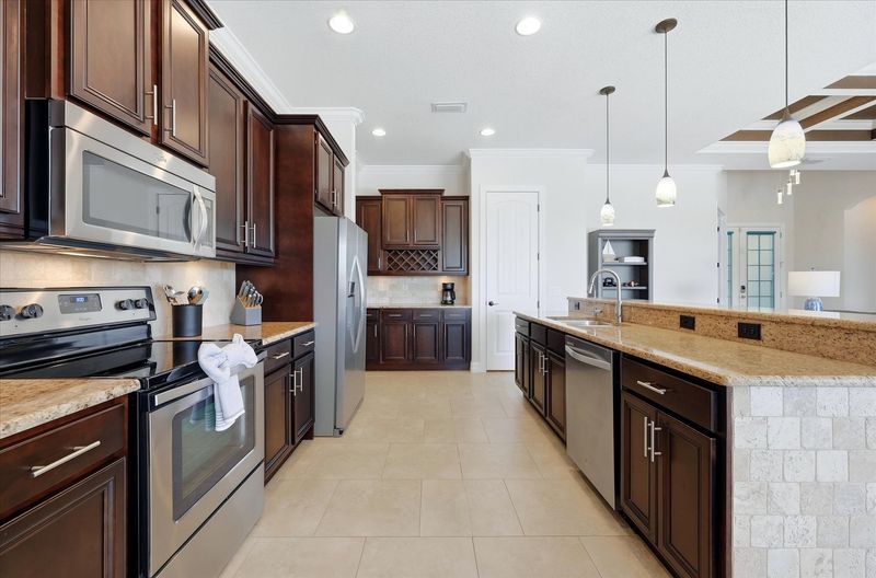 Fully-equipped kitchen overlooking the living room and dining areas. The kitchen features lots of countertop & storage space, and stainless-steel appliances. Kitchen island seats 4