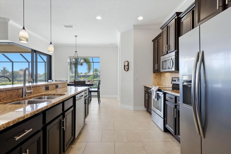 Fully-equipped kitchen overlooking the living room and dining areas. The kitchen features lots of countertop & storage space, and stainless-steel appliances. Kitchen island seats 4