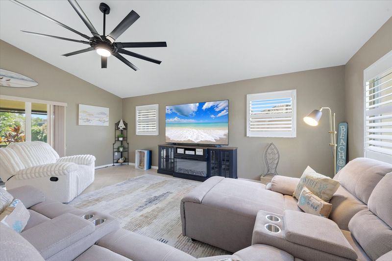Living room features lots of comfy seating, patio access, and 85-inch Smart TV