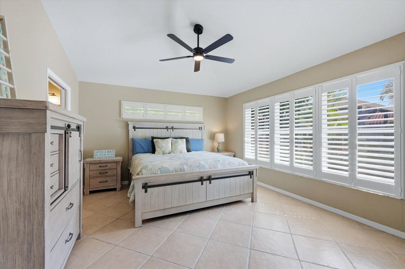 Primary bedroom with king bed, attached bathroom, and 46-inch smart TV