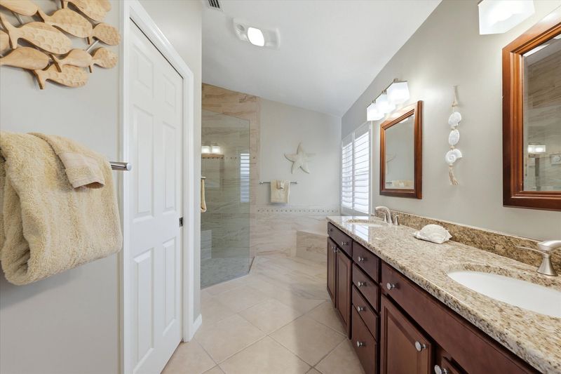 Attached bathroom with large walk-in shower and double vanities