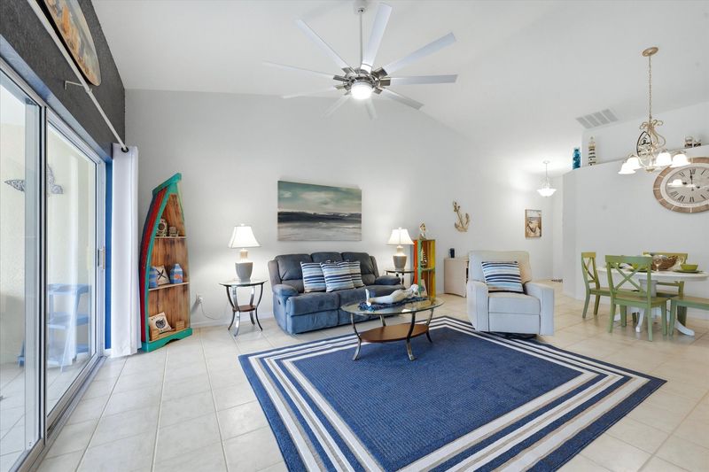 Large living space includes patio access overlooking the pond, and 75-inch Smart TV