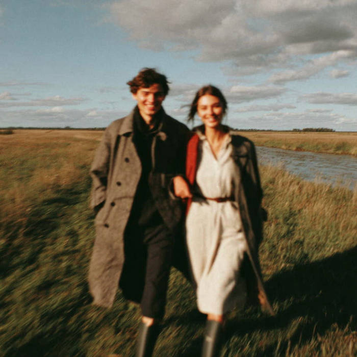 man and woman walking through a field
