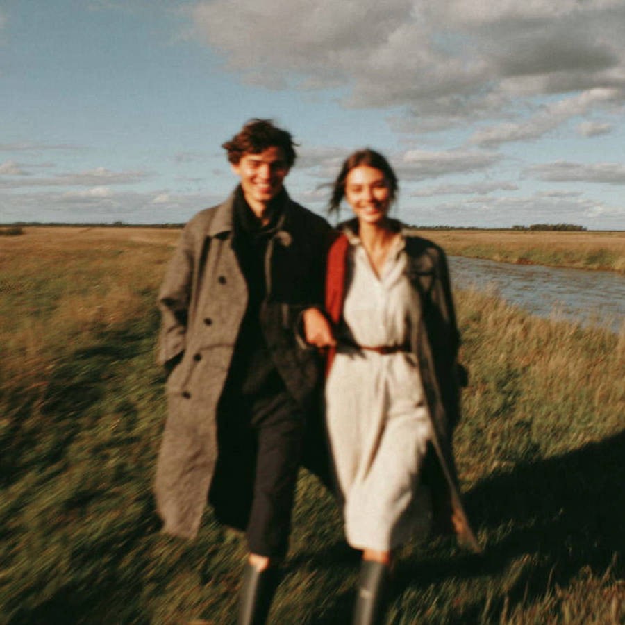 man and woman walking through a field