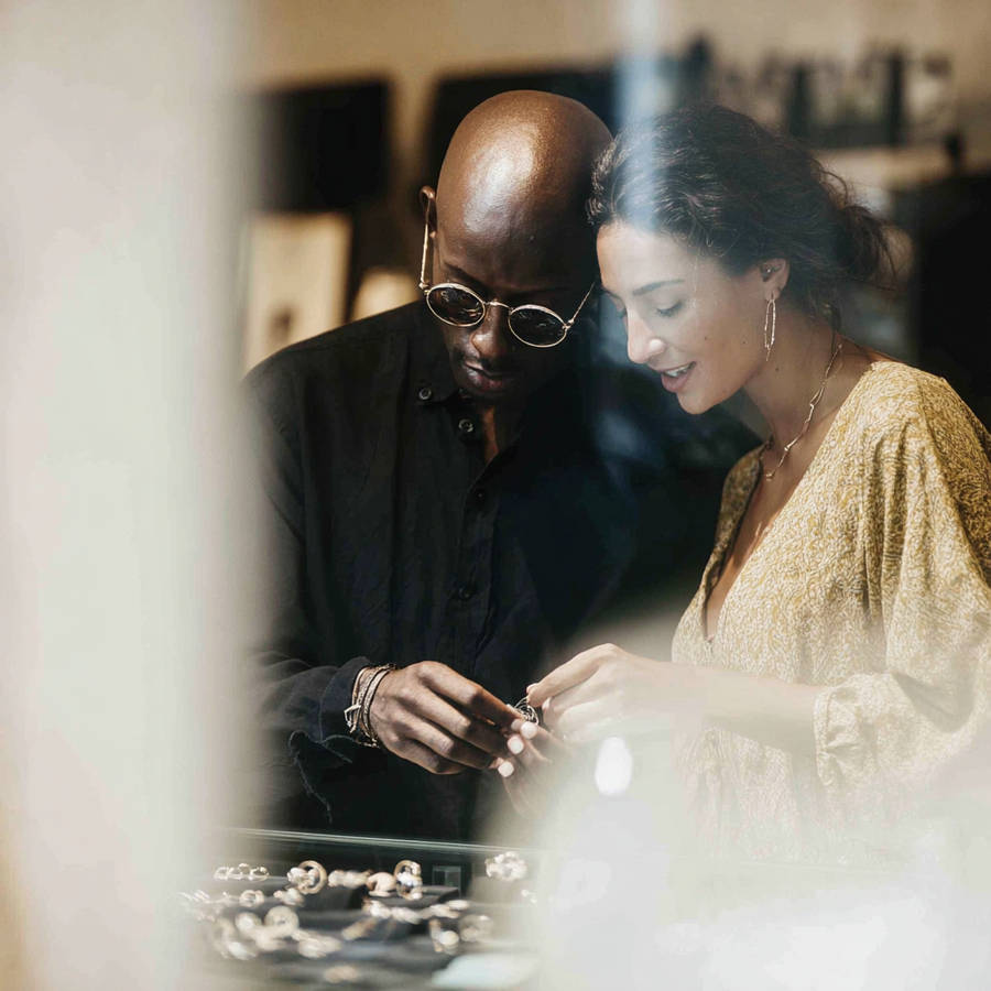 Couple browsing rings together in a jewellery shop, exploring bespoke engagement ring options