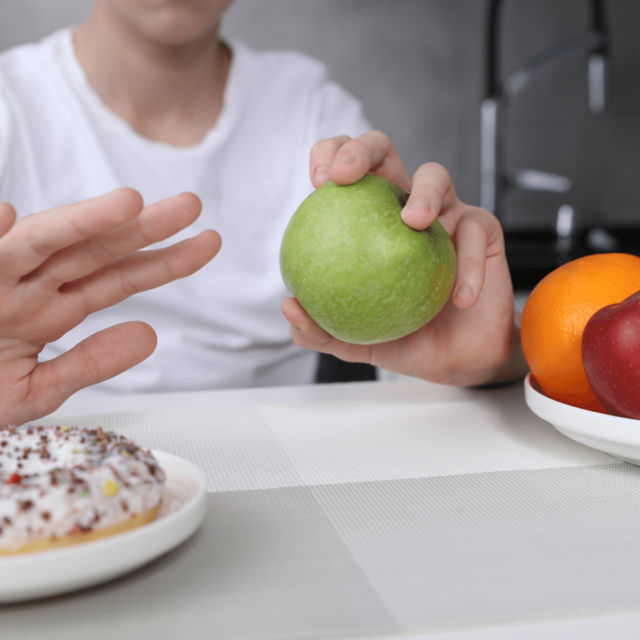 Child eating an apple rather than a donut