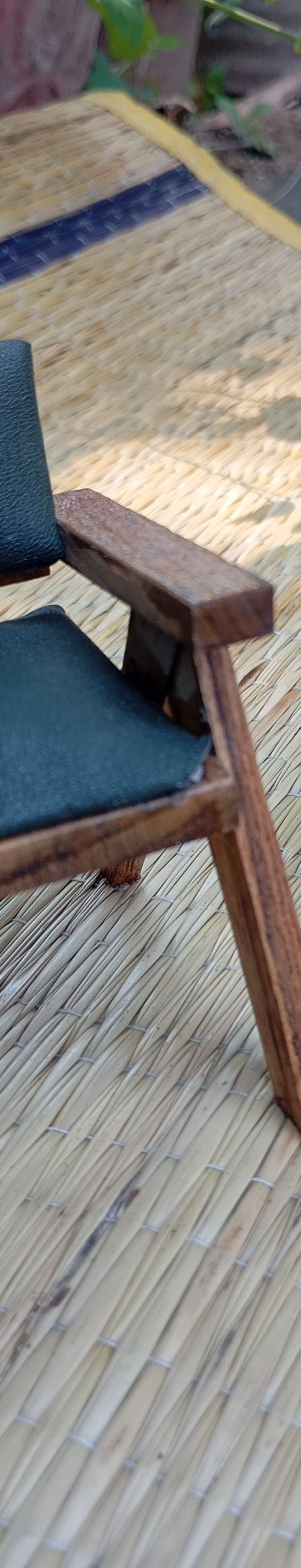 miniature chandigarh chair in front of a clenched fist statue