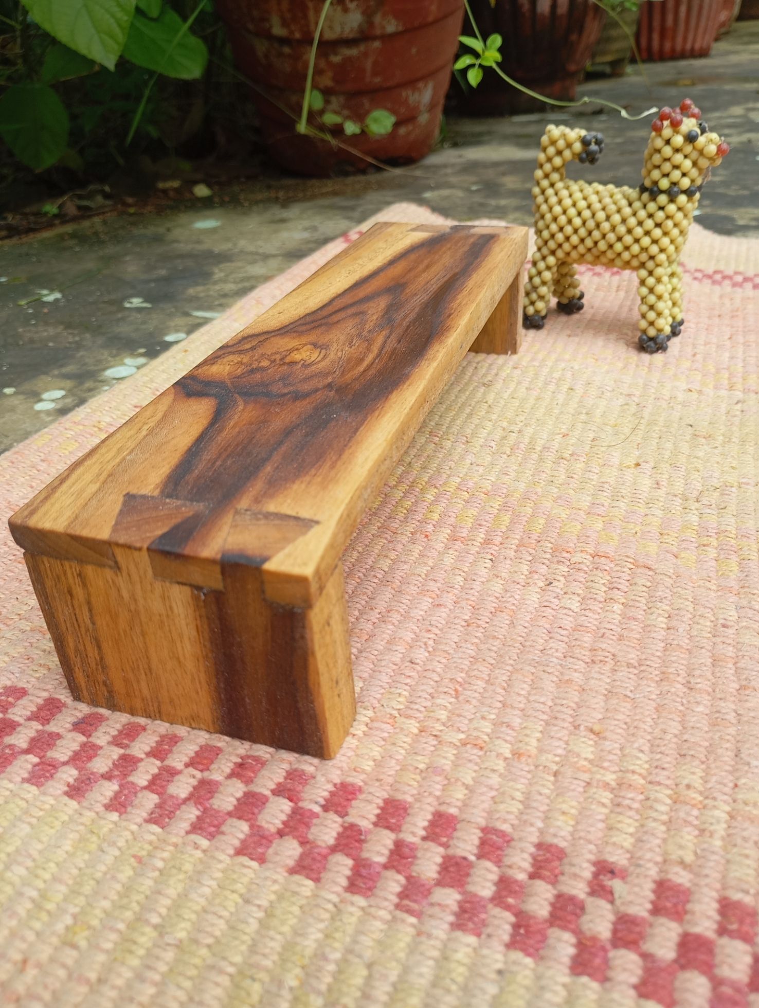 low teakwood bench with dovetail joinery