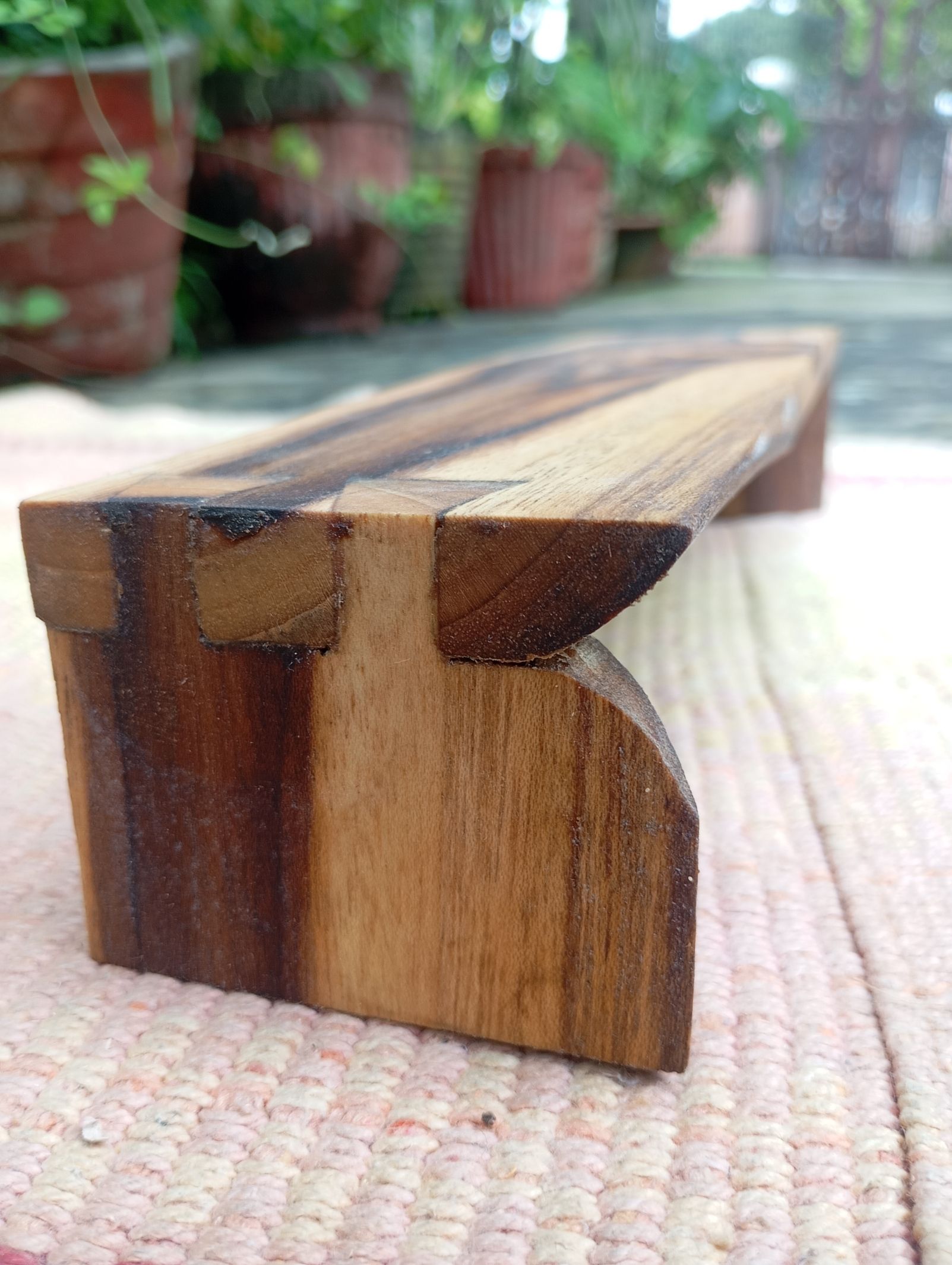 low teakwood bench with dovetail joinery