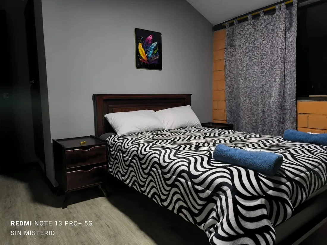Bedroom with a double bed and black and white bedding at Hágale Pues