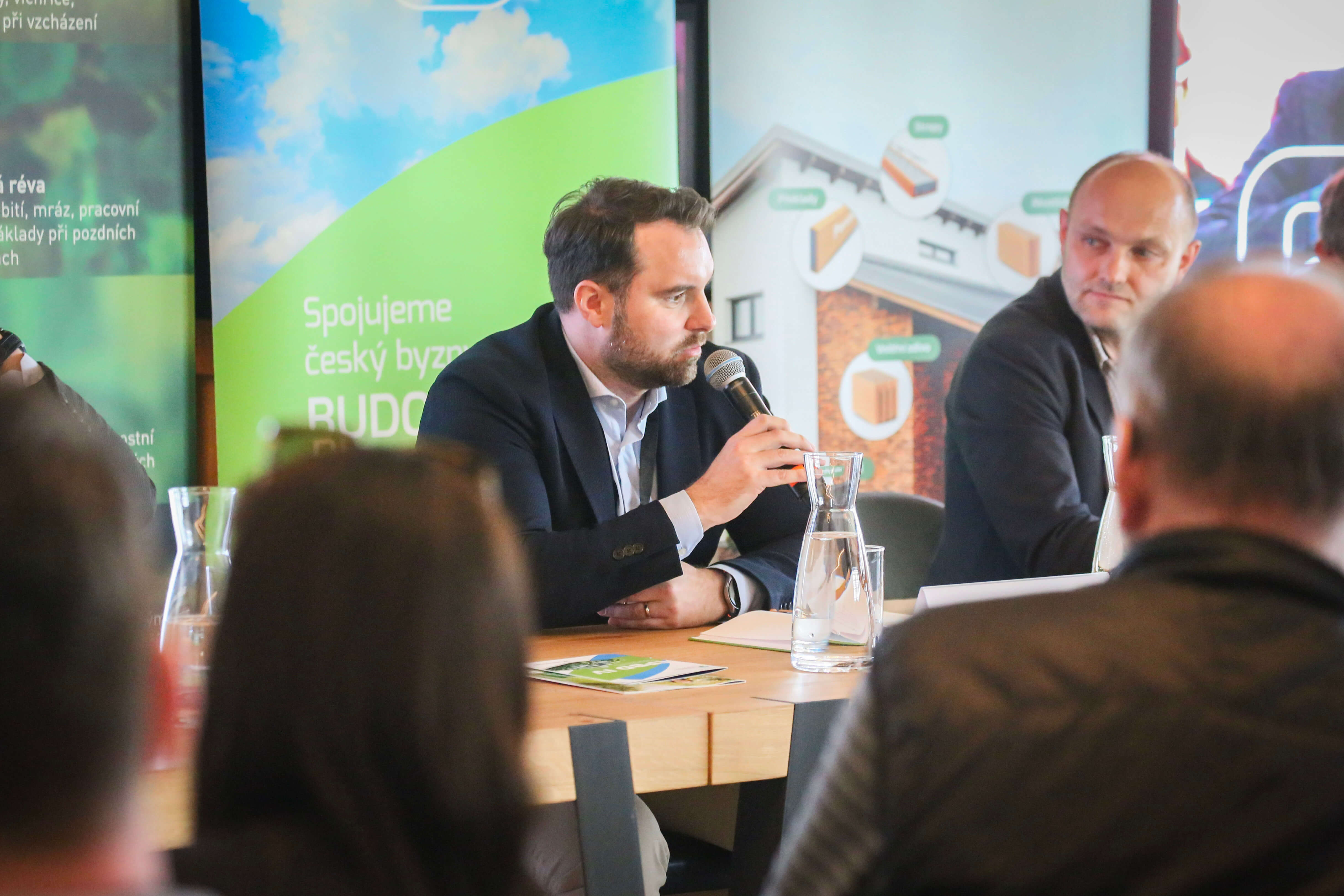 Na fotografii je panel diskuze. V čele stolu je Vladimír John