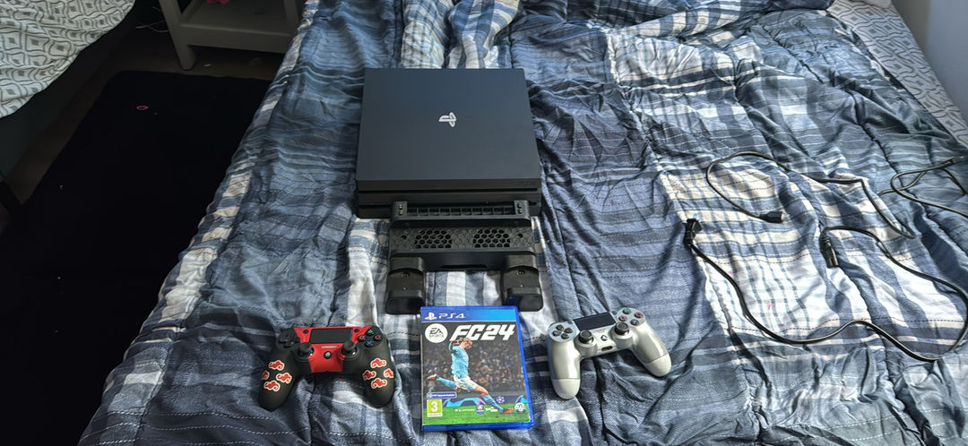 PlayStation 4 Pro and two controllers and the there is a custom one and a stand 