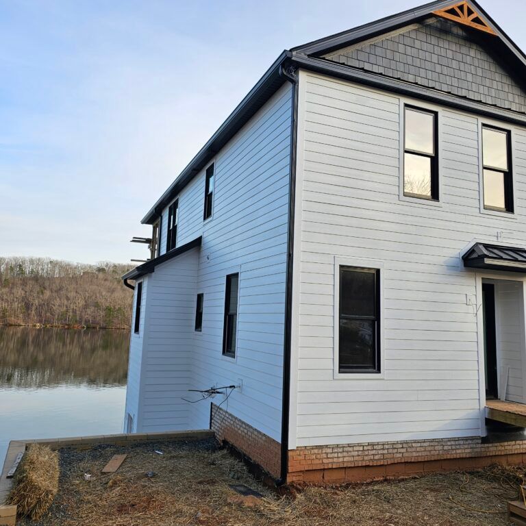 White house on a lake with new gutters.