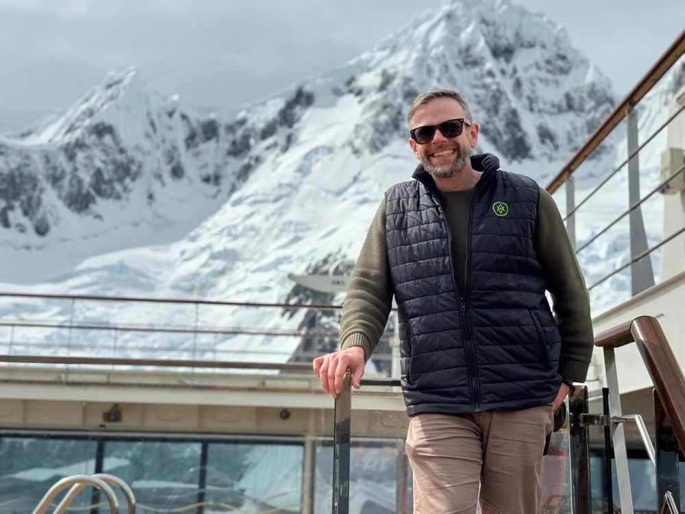 Joe, healthy and happy, on a boat in front of a glacier