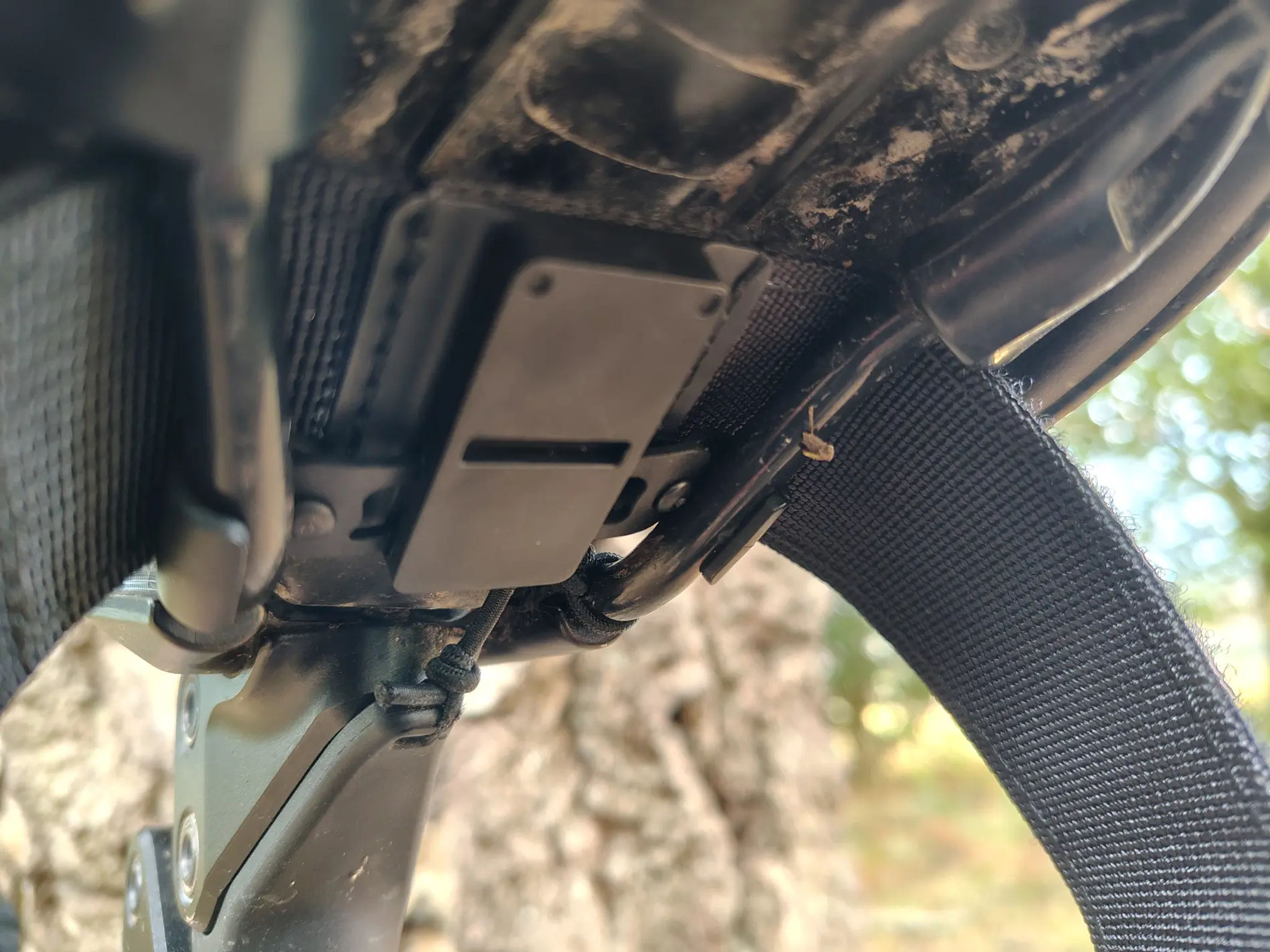 Detailed view looking underneath the saddle at the rail-mounted magnetic dock and release cord
