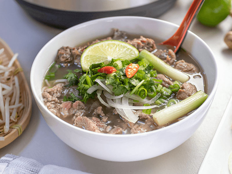 Cho phở thịt bò và gia vị vào tô để thưởng thức