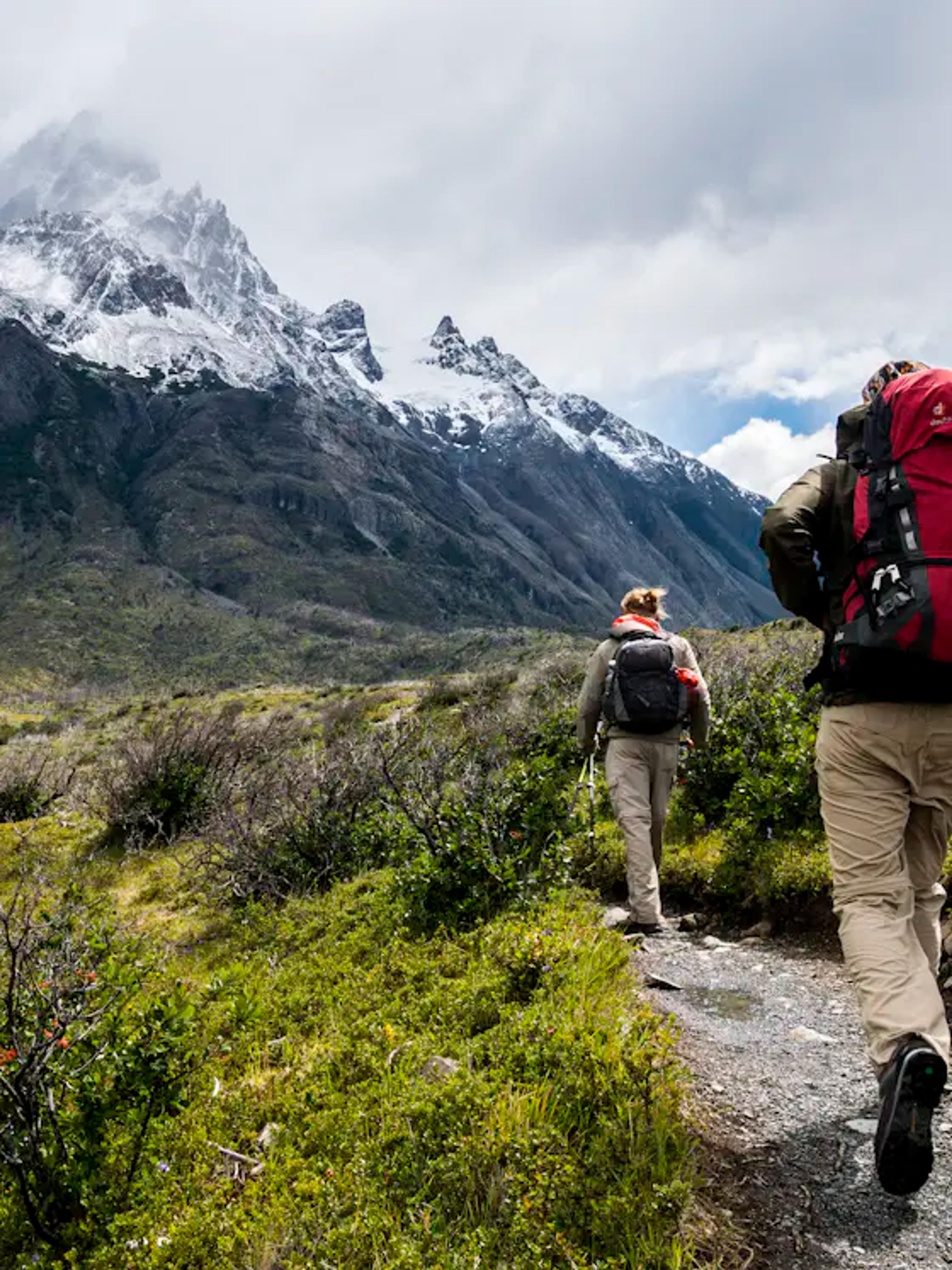 Hikers with backpacks on a mountain ridge trail