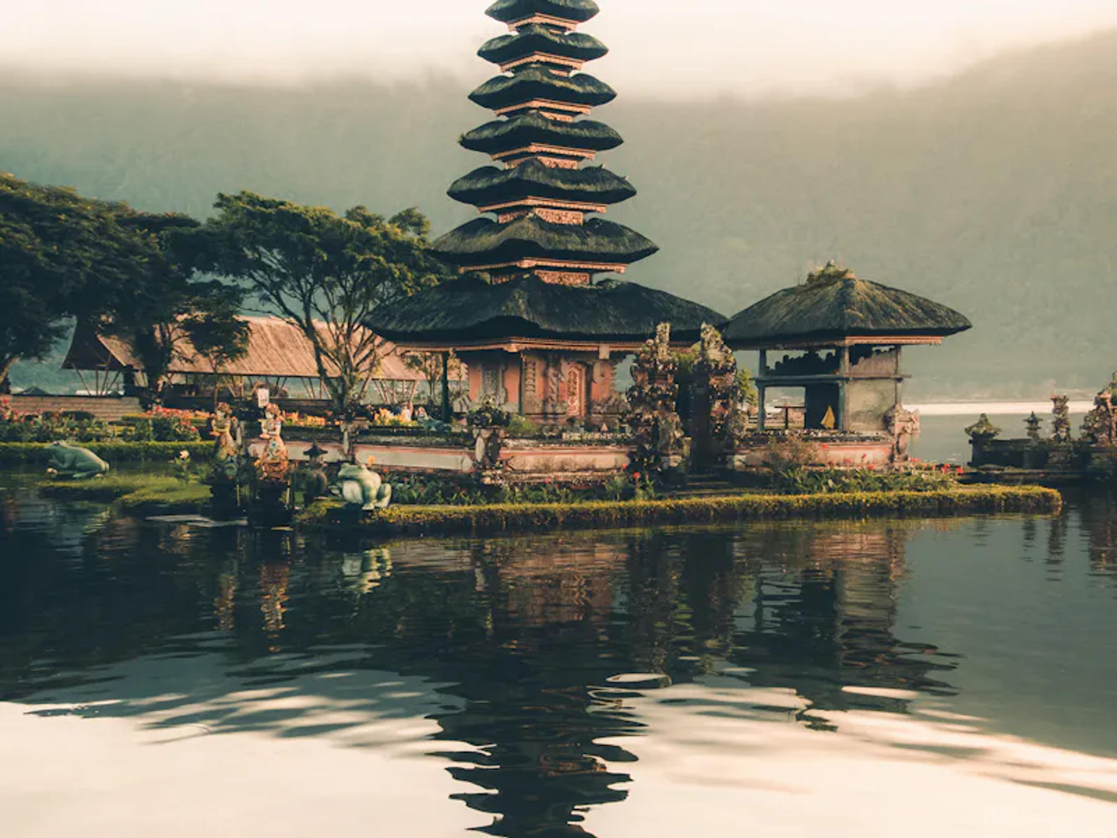 Balinese water temple with a tiered pagoda tower reflected in the lake