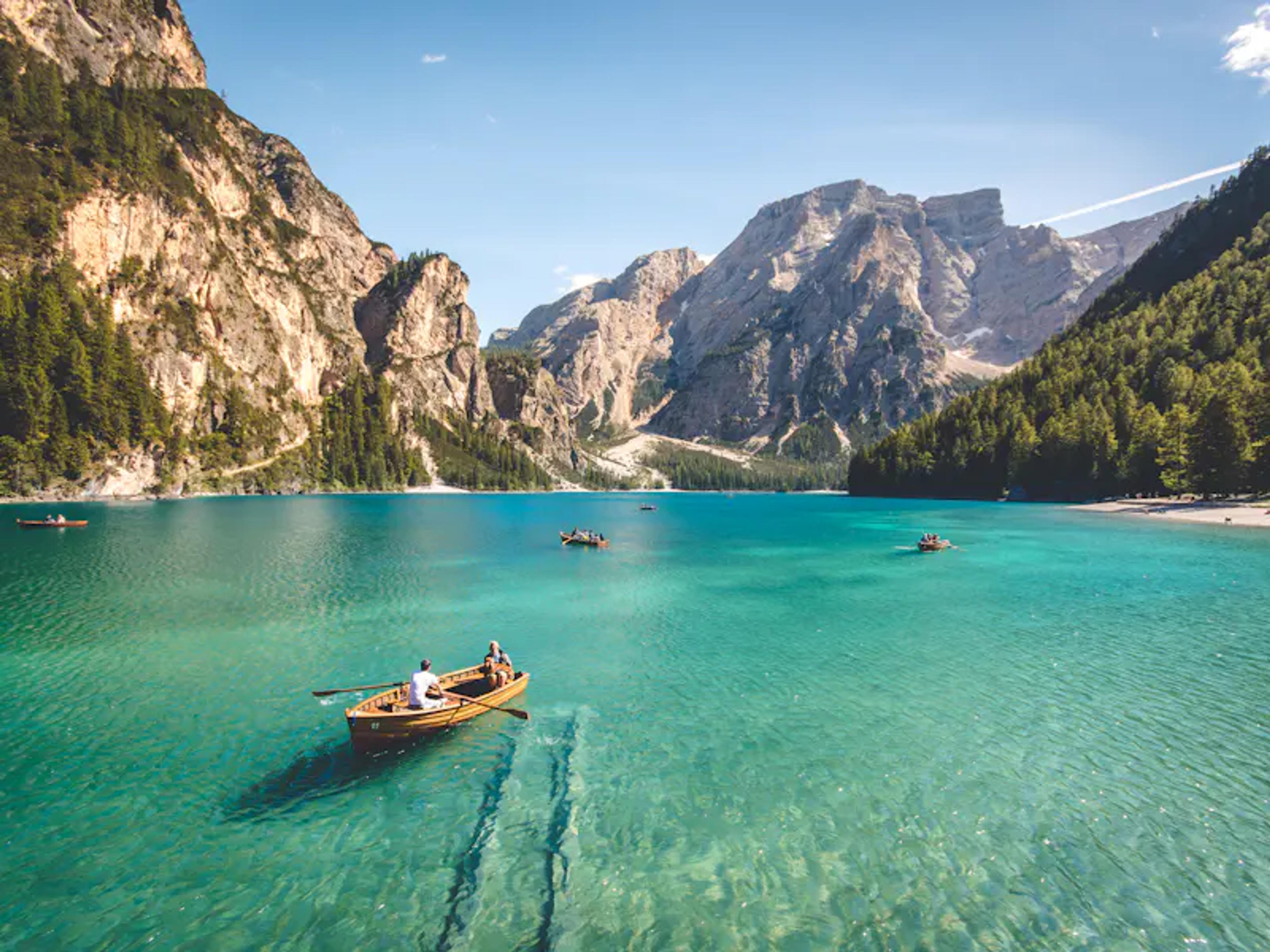 Wooden boats on a turquoise alpine lake surrounded by mountains