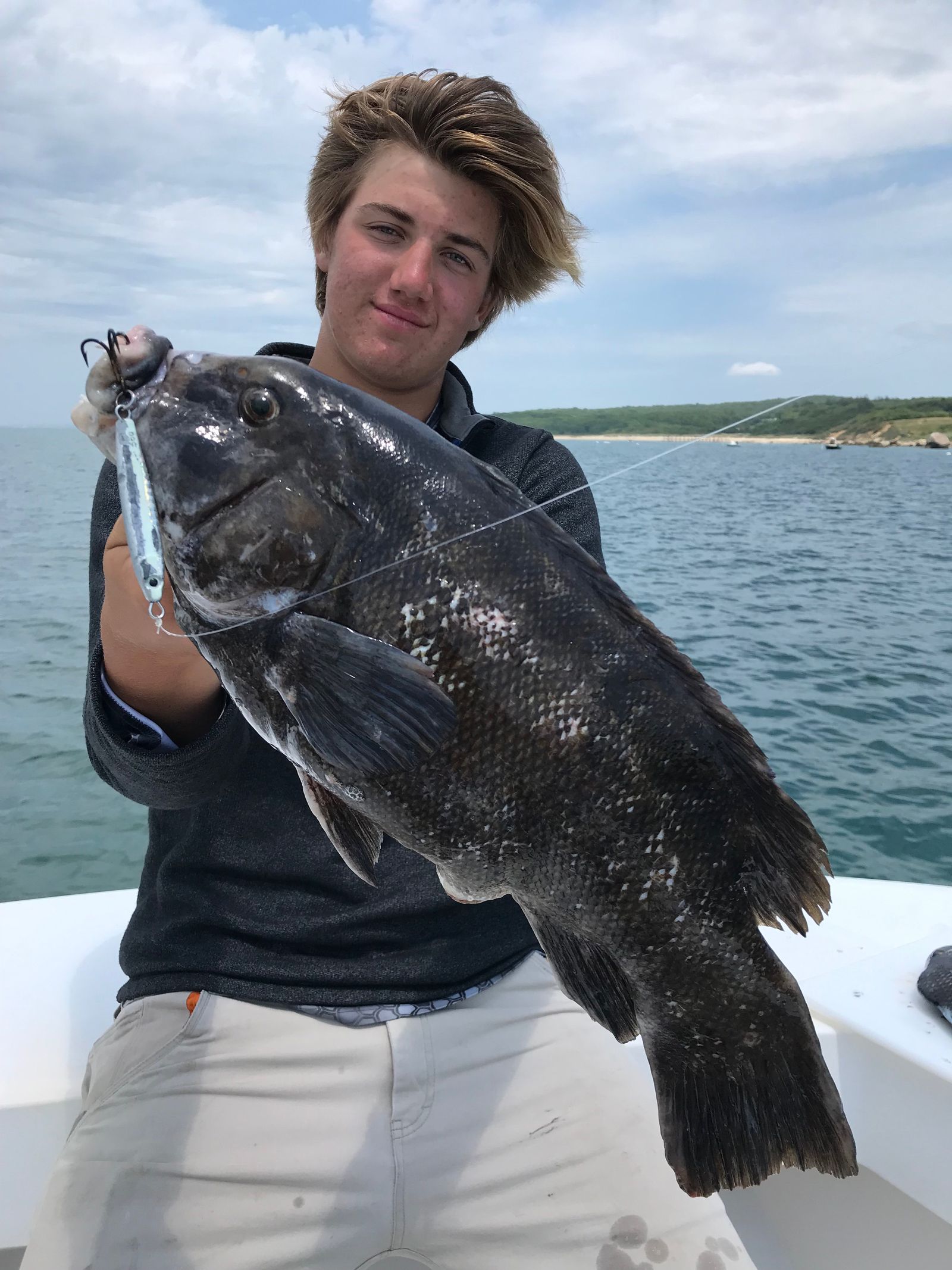 Young angler holding a big tautog caught on a Hogy Heavy Minnow