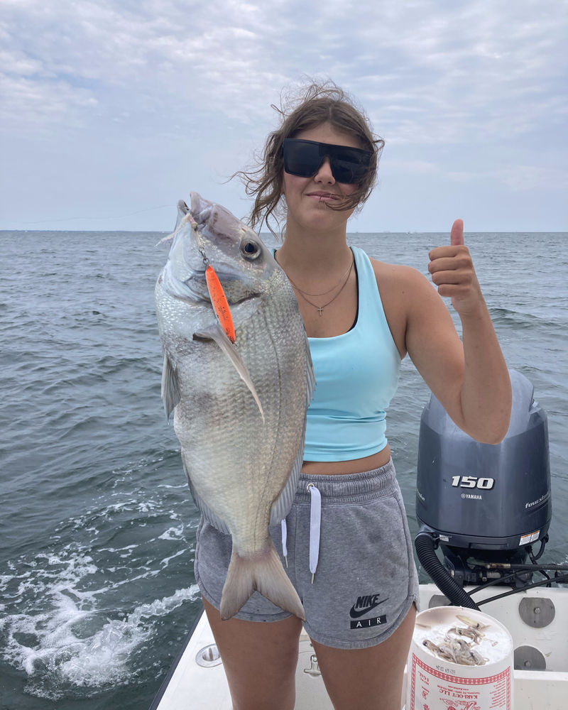 Angler holding a scup on the boat