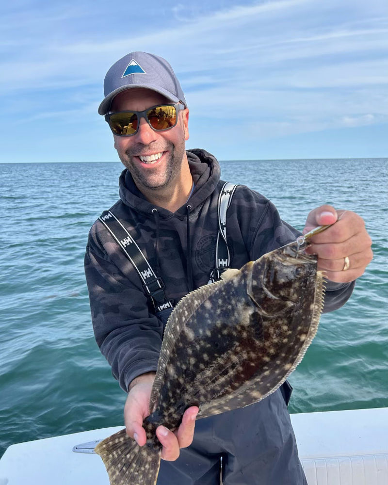 Angler holding a fluke on the boat