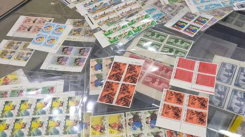 不同題材的郵票與連票放在玻璃檯面上
